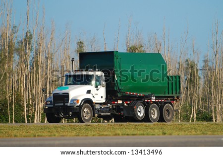 Green colored waste removal dump truck