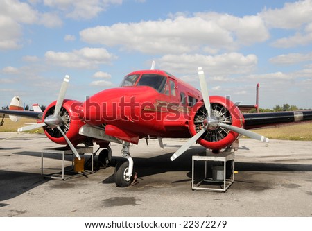 Vintage red propeller airplane undergoing repair