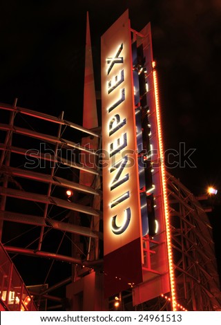Giant vertical neon sign advertising movie theater