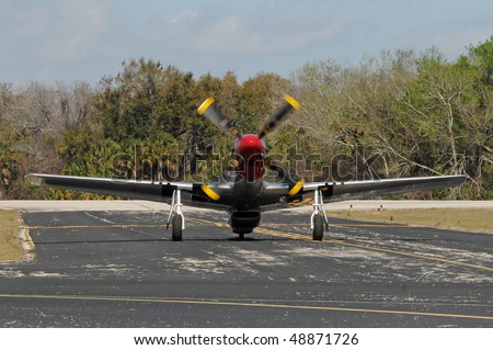 World War II era fighter plane taxiing on the ground