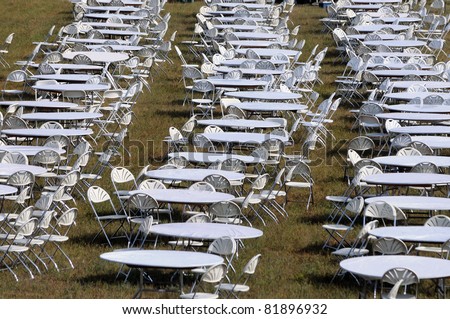 Multitude of empty white tables for outdoor event
