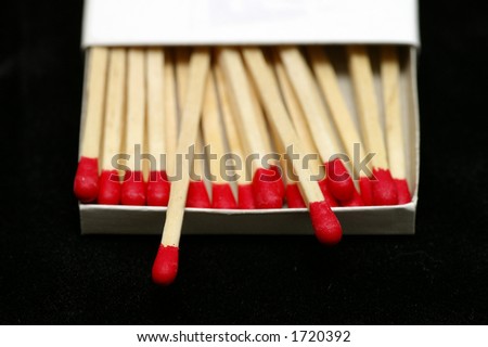 Closeup of Red Tipped wooden match sticks in a match box