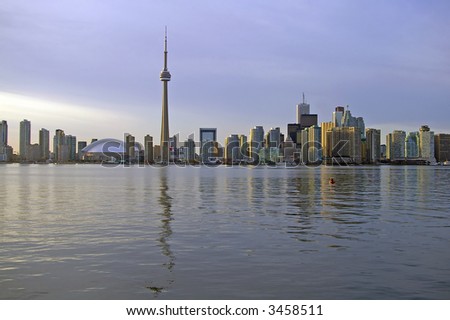 A view of the Toronto skyline including the CN Tower, Rogers Centre (formerly Skydome), and the Financial District, taken from Lake Ontario near sunset.