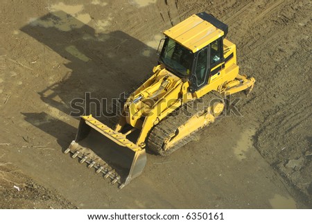 Overhead view of a yellow front end loader (bulldozer type machine) on a construction site