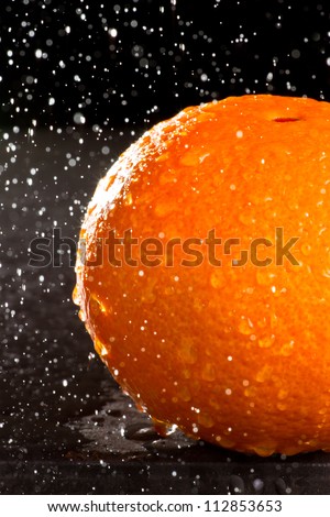 Navel orange with spray tn the air