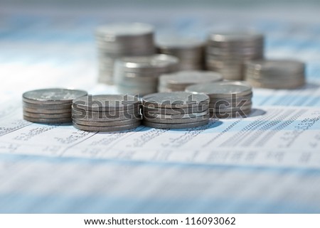 Stack of coins on stock market index