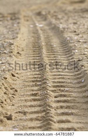 Car track in sand on a north sea beach, the imprint is fading away in the photo