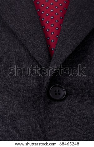 Close up of a dark grey professional business suit and a red power tie