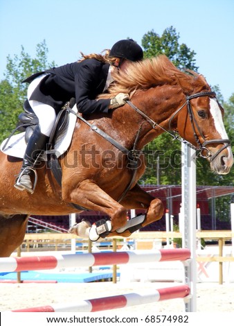 Young girl with hidden face jumping with brown horse