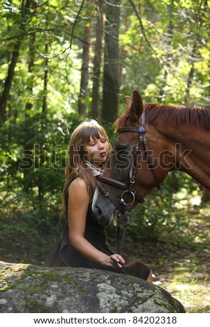 Beautiful teenager girl and chestnut horse in the forest un summer