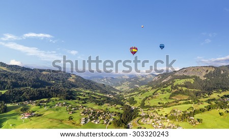 Panoramic view of mountains with three balloons
