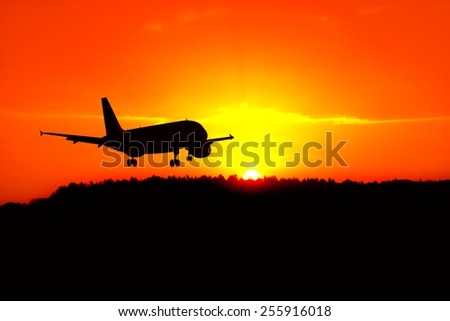 Silhouette of the plane landing above the sunrise