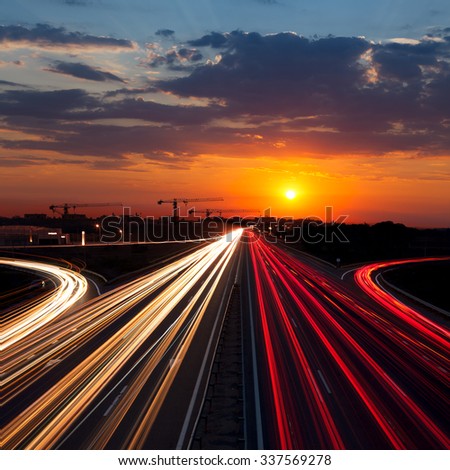 Speed Traffic at Sundown Time in the city - light trails on motorway highway at dusk, long exposure, urban background