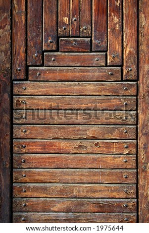 Old wooden boards fixed by screws. It is a fragment of a door.