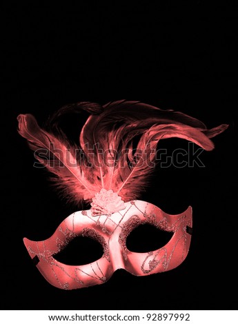 Fancy Pink Feathered Mask isolated on a black velvet background