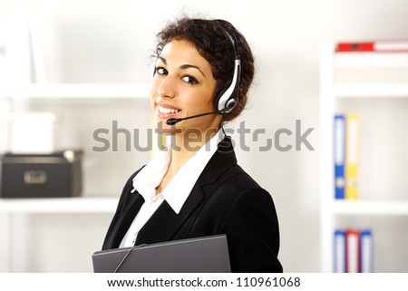 Young attractive brunette business girl standing and smiling with earphones on her ears