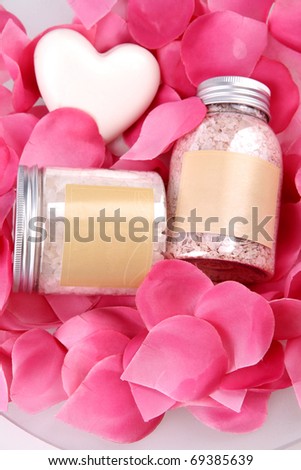 Two bottles of bathing salt with heart shaped soap and rose petals