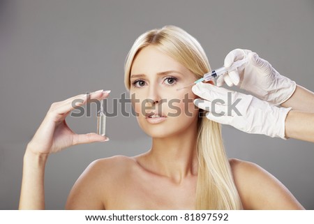 Young blonde getting injection, with calm expression on her face
