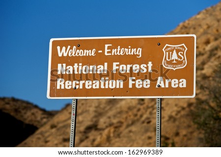 Sign welcomes visitors to a Recreation Fee Area of a National Forest.
