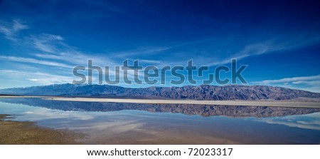 California mountains are reflected in collecting waters of Death Valley National Park.