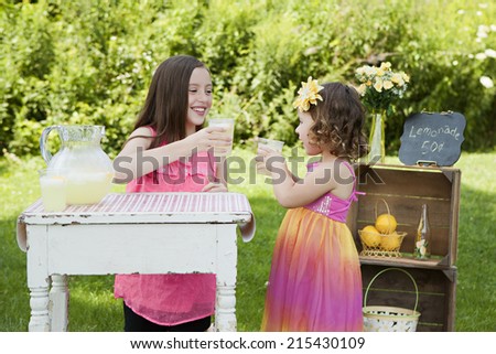 Cheers!  Two adorable sisters running a lemonade stand.