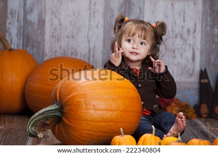 Pumpkins!  Adorable girl sitting next to a giant pumpkin and some smaller pumpkins.