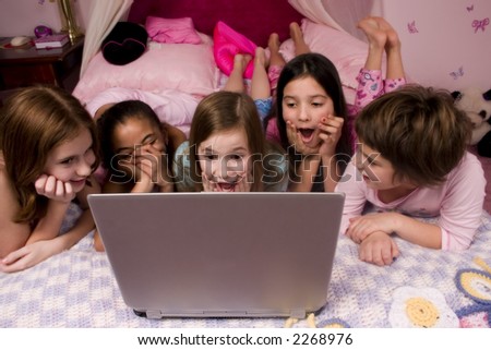 Friends at a slumber party playing on the computer.