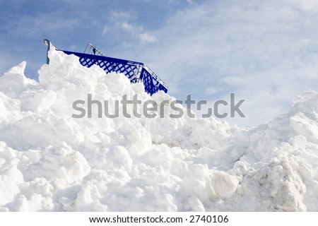 Shopping cart at the top of tall snow bank.  Lots of space for text.