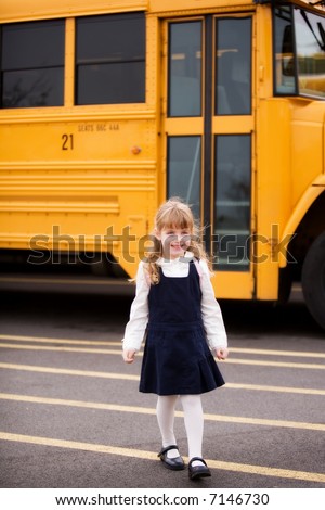 Young elementary girl walking away from the school bus.