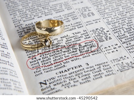 stock photo Wedding rings place on an open Bible to a verse in the book