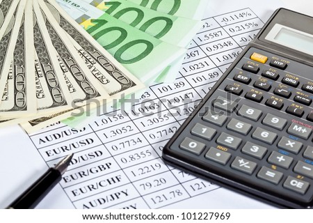 Business analytics: closeup of paper money, calculator and pen on currency cross-rate table