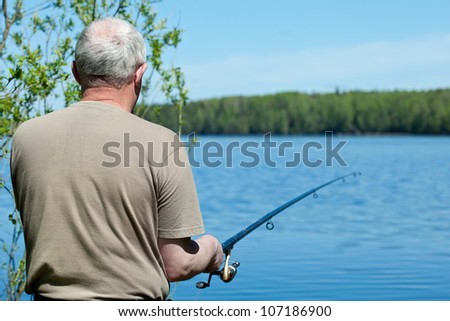 Fishing man with a rod at the lake