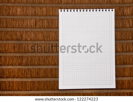 Squared paper loose-leaf note sheet on bamboo background