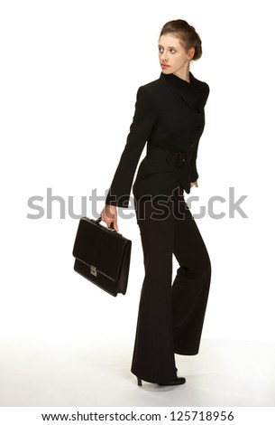 Young woman in a business suit with briefcase turning back; white background