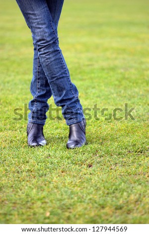 Legs of a young woman standing on a football ground