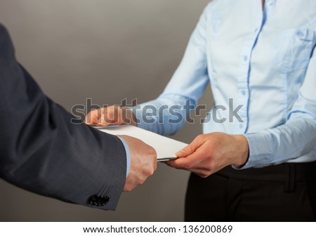 Businessman giving some documents to his secretary, grey background