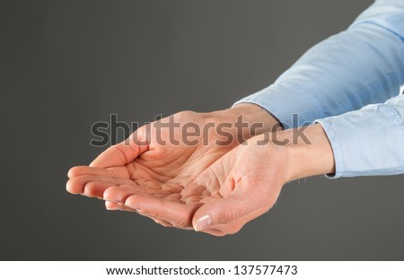 Woman\'s hands outstretched, grey background