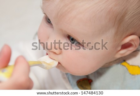 Parent feeding a baby; close-up shot