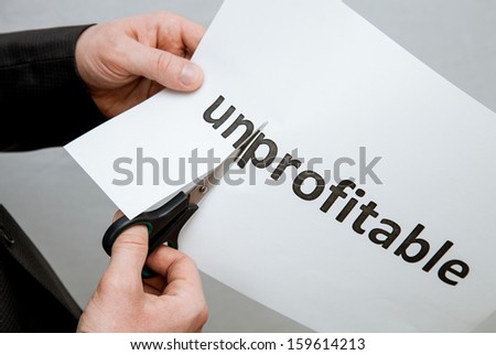 Man cutting inscription on a paper with scissors - closeup shot