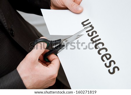 Man cutting inscription on a paper with scissors - closeup shot