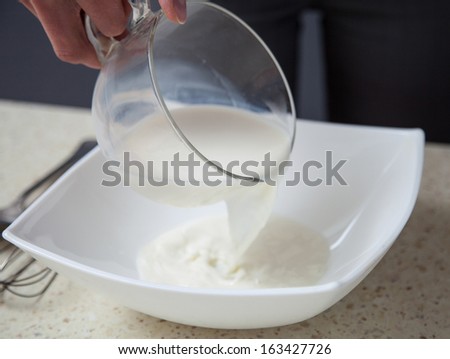 Housewife filling milk in a white bowl