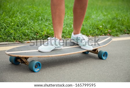 Girl skating on a longboard outdoors