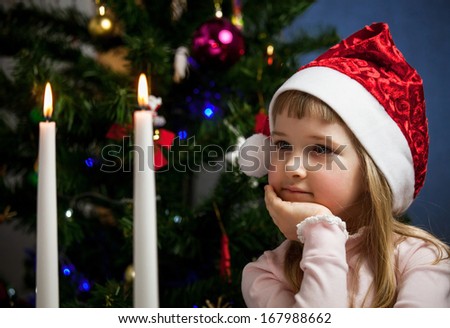 Pretty little girl looking on fire of candles - closeup shot