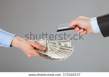 Business people exchanging credit card and money - closeup shot of hands