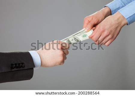 Business people hands pulling money, closeup shot on grey background