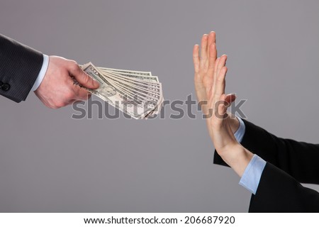 Human hands rejecting an offer of money on grey background