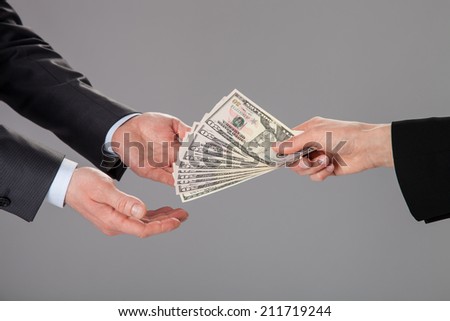Businessman\'s hands accepting an offer of money on grey background