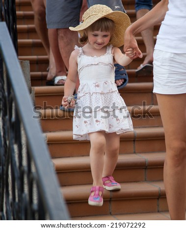 Mother holding daughter\'s hand in crowd