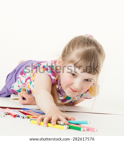 Pretty little girl taking many felt-tip pens, white background