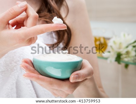Closeup of woman hands holding a bowl with nourishing mask for applying to hair or skin; beauty and spa concept